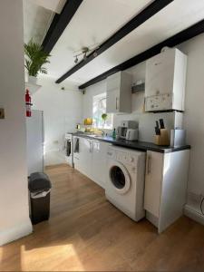 un lavadero con lavadora y secadora en Cozy Central Flat Oxford, en Oxford