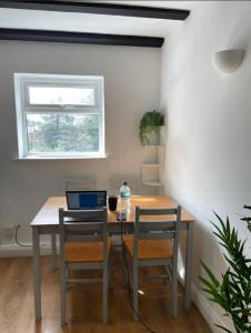 mesa de comedor con 2 sillas y ordenador portátil en Cozy Central Flat Oxford, en Oxford
