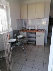 a kitchen with a table with two glasses on it at Studio Jasna in Brzac +16 photos
