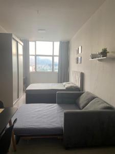 une chambre avec trois lits et un canapé et une fenêtre dans l'établissement Apê da Praça, à Rio de Janeiro 22 autres photos
