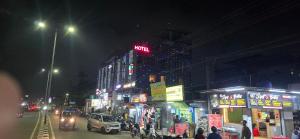 a busy city street at night with cars and buildings at HOTEL PARADISe in Guwahati