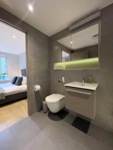 a bathroom with a toilet and a sink and a bed at Luxury Apartments in Westminster in London