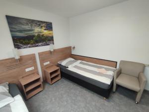 巴特拉珀瑙My-Skypalace Bad Rappenau的一间带床和椅子的小卧室