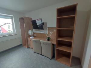 巴特拉珀瑙My-Skypalace Bad Rappenau的客房设有书桌、电视和书架。