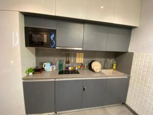 a kitchen with grey cabinets and a sink at Luxury Vello Stay Supernova in New Delhi +7 photos