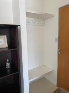 a closet with a white shelf and a door at Dpto 9 DE JULIO in Villa María