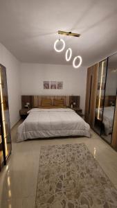 une chambre avec un grand lit et un tapis dans l'établissement Rehab Elegant Apartment - New Cairo, à Burg el-Ḥudûd