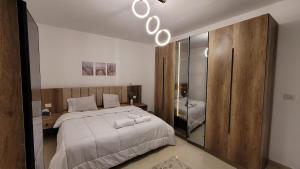 une chambre avec un grand lit et un miroir dans l'établissement Rehab Elegant Apartment - New Cairo, à Burg el-Ḥudûd