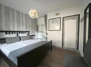 a bedroom with a large bed and a chandelier at Chez Flo & Marc - Chambres d'hôtes climatisées avec piscine - Blois & Chaumont in Chouzy-sur-Cisse +48 photos