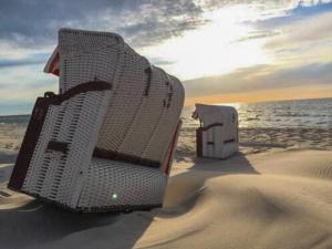 - deux chaises assises dans le sable sur la plage dans l'établissement Künstlerhaus, à Ribnitz-Damgarten
