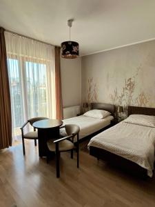 a bedroom with two beds and a table and a dining room at Pokoje goscinne U Marynarza in Łeba