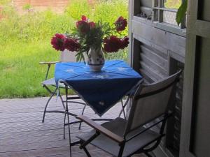 - une table avec des chaises et un vase de fleurs sur la terrasse couverte dans l'établissement Künstlerhaus, à Ribnitz-Damgarten 35 autres photos