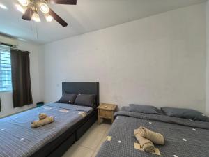 two beds sitting next to each other in a bedroom at Langkawi A&A Homestay 13 Pax in Kuah