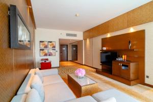 uma sala de estar com um sofá e uma televisão em Asiana Hotel Dubai no Dubai