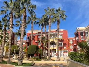 a group of palm trees in front of a building at Casa Rivero in Los Alcázares