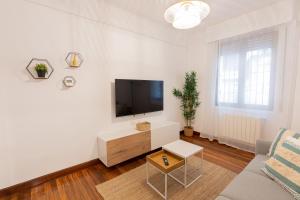 a white living room with a flat screen tv at Bilbao Urban Stay in Bilbao