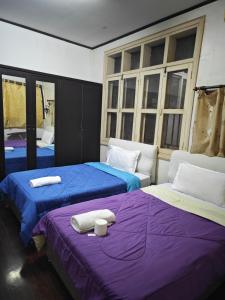 two beds sitting next to each other in a room at Gold house apartment in Vientiane