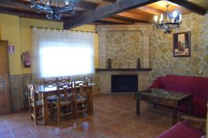 a living room with a table and a fireplace at Alojamiento Macarena in Burunchel