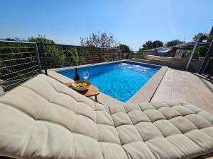 - un grand canapé installé en face de la piscine dans l'établissement Apartman Marlera s privatnim bazenom, à Ližnjan