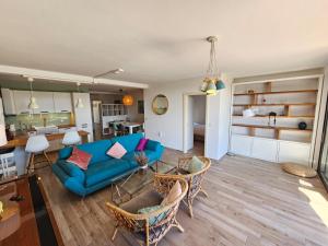 un salon avec un canapé bleu et des chaises dans l'établissement Apartman Marlera s privatnim bazenom, à Ližnjan