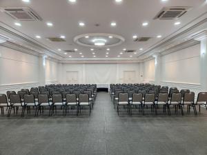 an empty room with chairs and a screen at Lizon Curitiba Hotel in Curitiba