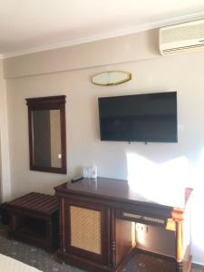 ein Wohnzimmer mit einem Flachbildfernseher an der Wand in der Unterkunft Hotel President in Scorniceşti