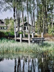 ein Haus mit einem Dock neben einem Wasserkörper in der Unterkunft Tiny House with a Stunning Lake View 30 Min from Gothenburg in Gråbo