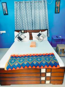 a bedroom with a bed with a wooden headboard at Studio Apartment with private entrance, behind DLF and near L&T, RMZ IT park and close to SRMC & MIOT Hospital in Chennai