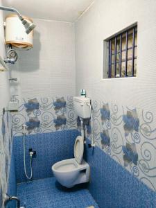 a bathroom with a toilet in a blue room at Studio Apartment with private entrance, behind DLF and near L&T, RMZ IT park and close to SRMC & MIOT Hospital in Chennai