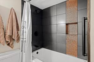 a bathroom with a tub and a shower with a shower curtain at Stylish 1BR Free Attraction Tix Views! in Gatlinburg