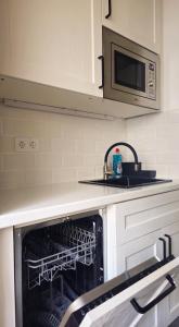 a kitchen with an open oven with a microwave at Beachfront Arguinegin by Canary deluxe in Arguineguín