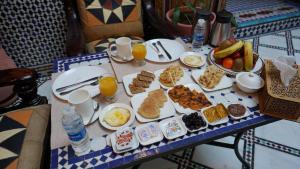 a table topped with plates of food and drinks at Riad Green House in Fès