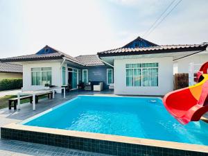 a swimming pool in front of a house at Victoria Poolvilla Pattaya by Chon in Nong Prue