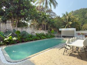 a swimming pool in a yard with a table and chairs at Eskep Estate - Private Villas in Phumĭ Ŏng Char