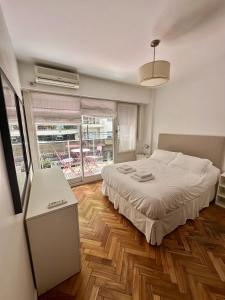 a bedroom with a bed and a large window at Cozy Studio in the heart of Recoleta in Buenos Aires