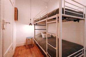 a bedroom with two bunk beds and a stool at Lisbon Sant'Ana Alcantara 2br apart in Lisbon