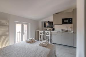 a bedroom with a bed and a kitchen with white cabinets at D'Annunzio Apartment in the heart of Navigli in Milan