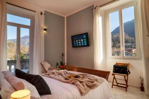 a bedroom with a bed and a tv and windows at Residenza Maddalena Lago Maggiore Wifi & View in Castelveccana