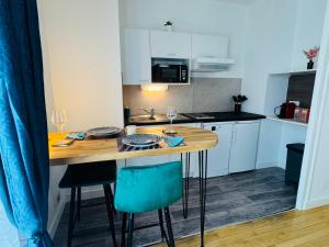 a small kitchen with a wooden table and chairs at Centre-ville, parking facile,confortable in Chalon-sur-Saône