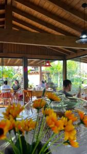 a table with flowers on it in a restaurant at Pousada Aurora in Praia do Rosa