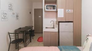 a small kitchen with a sink and a table with chairs at Eimy's Place at Urban Deca Mandaluyong by RedDoorz in Manila
