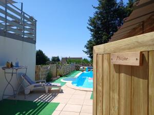 a wooden fence with a pool in a backyard at Gîte avec piscine - 4 personnes - Pays Cathare in Cuxac-Cabardès