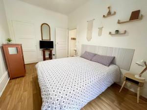 a bedroom with a bed and a tv in it at Chez Mamema in Colmar