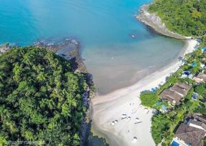 an aerial view of a beach and the ocean at Villa in the middle of the Atlantic Forest in private condo in Guarujá