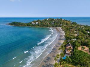 an aerial view of a beach with houses and the ocean at Villa in the middle of the Atlantic Forest in private condo in Guarujá