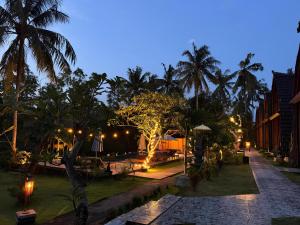 a resort with palm trees and lights at night at Meket Bungalows in Nusa Penida