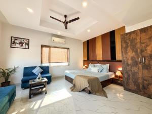 ハリドワールにあるHotel Shoolin Suites Boutique Haridwarのベッドルーム1室(ベッド1台、青い椅子付)