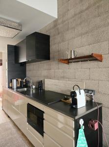 eine Küche mit einer schwarzen Arbeitsplatte in einem Raum in der Unterkunft Industriële WOW! Private studio 35m2 in Amsterdam