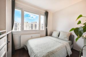 a bedroom with a bed and a window at Appartement proche du Parc de la Tête d'Or - Garage Gratuit in Villeurbanne