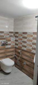 a bathroom with a toilet and a wall at Chittu villa in Jhūsi